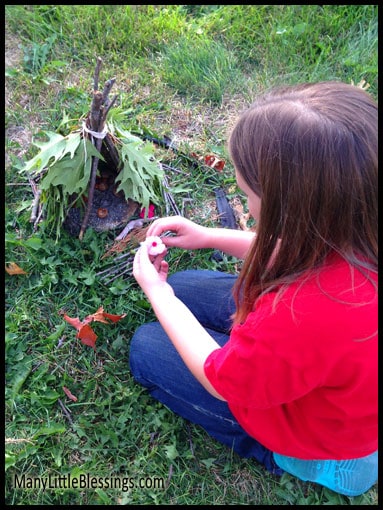 decorating her teepee-style fairy house